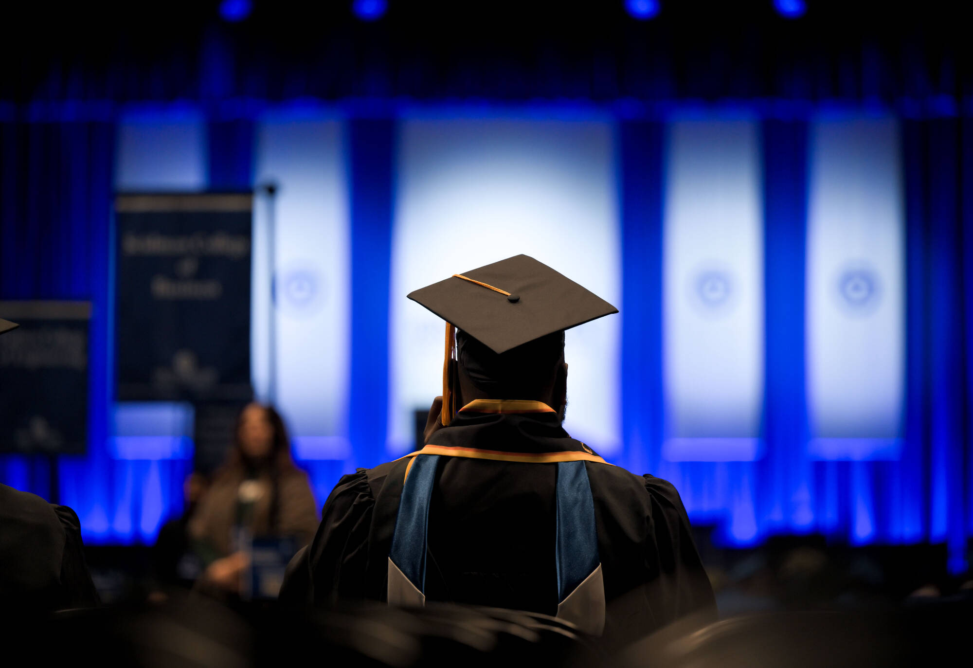 Back of a student in black cap and gown at GVSU's Fall 2025 graduation ceremony